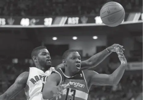  ?? STEVE RUSSELL/TORONTO STAR ?? Raptor Amir Johnson knocks the ball away from Kevin Seraphin of the Wizards in Friday night’s game. Johnson finished with 18 points and 13 rebounds.