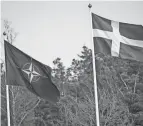  ?? FREDRIK SANDBERG/TT NEWS AGENCY/AFP ?? The NATO flag, left, is raised next to a Swedish flag at a ceremony in Stockholm on Monday.