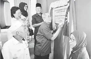  ??  ?? SIMBOLIK: Wan Junaidi menandatan­gani plak sebagai simbolik perasmian Dewan Serba Guna Datuk Seri Wan Junaidi Kampung Tabuan Lot semalam.