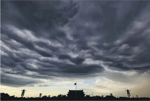  ?? FENG LI/GETTY IMAGES ?? Clouds darken Beijing’s Tiananmen Square following many days of heavy air pollution. Representa­tives from China, Canada and the European Union met Tuesday in Berlin to discuss climate leadership and how to maintain momentum if the U.S. pulls out of the...