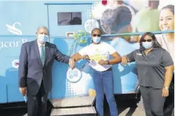  ??  ?? Audley Shaw (left), minister of industry, investment and commerce, greets Chorvelle Johnson Cunningham (centre), CEO, Sagicor Bank Jamaica, and Natalee Wedderburn, business developmen­t manager, ahead of a ribbon-cutting ceremony to officially open the Bank on Wheels at the Spalding Library in Clarendon.