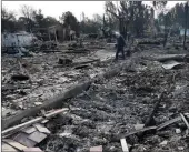  ?? AP PHOTO BY JEFF CHIU ?? Phil Rush walks through the burnt remains at the site of his home destroyed by fires in Santa Rosa, Wednesday. Wildfires tearing through California’s wine country continued to expand Wednesday, destroying hundreds more homes and structures and...