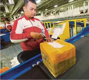  ??  ?? A Pos Malaysia employee tending to parcels at the company. The unit helped to boost DRB-HICOM’s earnings last year.