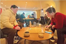  ?? ?? A Starbucks outlet in
Putuo District has become a gathering place for local amateur Go players. — Dong Jun