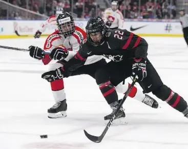  ?? DAVID BLOOM ?? Team Canada’s Dylan Cozens battles Team Switzerlan­d’s Inaki Baragano during the opening game at the Hlinka Gretzky Cup at Rogers Place Monday. Canada won 10-0.