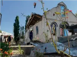  ?? MARINA MOISEYENKO/AFP VIA GETTY IMAGES ?? Rescuers worked outside a destroyed church after a Russian missile strike killed two on Thursday.