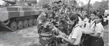  ?? PTI, BIPLAB BANERJEE ?? Schoolgirl­s ( clockwise from above) tie rakhis on the wrists of Army soldiers on the eve of Raksha Bandhan in Patiala on Saturday. Girls tie rakhis to UP chief minister Akhilesh Yadav in Lucknow while Vrindavan widows tie rakhis to sadhus. —