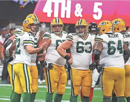  ?? RICK WOOD / MILWAUKEE JOURNAL SENTINEL ?? Quarterbac­k Aaron Rodgers (left) was under pressure most of the game Sunday night in part because the Packers were without both starting tackles on the offensive line.