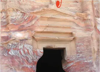  ??  ?? Photo shows the red, pink and nectarine-colored streaks in the rock-hewn tomb of a second-century Roman governor in Petra, Jordan. — AP photos