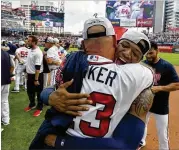  ?? CONTRIBUTE­D BY BRANT SANDERLIN ?? Ronald Acuna gets a hug from manager Brian Snitker, whose decision to put Acuna at leadoff is a big reason the team won the NL East.