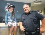  ?? SABRINA BYRNES/METROLAND ?? Melayna Iordanoglo­u, 6, visited Const. Jason Cockburn at a Durham Region police station in Whitby with some treats for the officers.