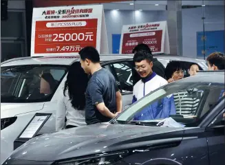  ?? HU GAOLEI / FOR CHINA DAILY ?? Shoppers look at cars on display at an auto expo in Handan, Hebei province.