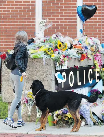  ?? ANDREW VAUGHAN / THE CANADIAN PRESS ?? Flowers are placed on a makeshift memorial outside the police station in Fredericto­n on Saturday. Two city police officers were among four people who died in a shooting in a residentia­l area Friday. Matthew Vincent Raymond has been charged with four counts of first-degree murder.