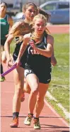  ?? ARCENIO TRUJILLO/THE TAOS NEWS ?? Taos senior Cora Cannedy takes the baton from Abigail Gunther during the medley relay at the District 2-4A track and field meet on May 4 at Las Vegas Robertson’s Cardinal Stadium. The Lady Tigers won the race in 4 minutes, 31.73 seconds, but have a...