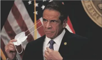  ?? GOV. ANDREW CUOMO SHANNON STAPLETON/REUTERS ?? takes off his face mask before a news conference in New York on Monday.