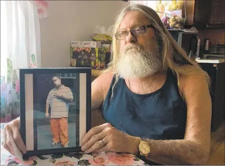  ?? Del Quentin Wilber Los Angeles Times ?? JOHN SLIGER holds a photo of his son Justin, who died of an opioid overdose in 2014. Justin was visiting a pain clinic in Knoxville, Tenn., and selling pills for extra cash, his father said. “I didn’t think he was using enough to kill himself over…. We all took it hard, still do.”