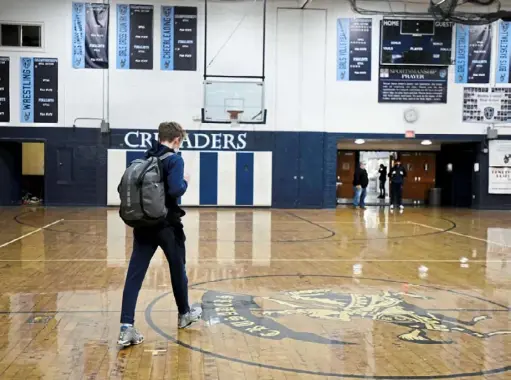  ?? Barry Reeger/For the Post-Gazette ?? Nevan Crossey leaves the gymnasium after Bishop Canevin forfeited its PIAA quarterfin­al game against Berlin Brothersva­lley.