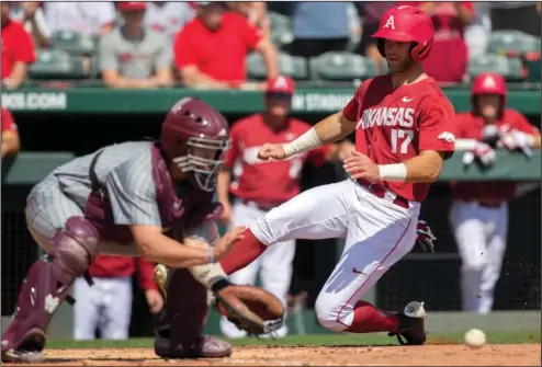  ?? NWA Democrat-Gazette/Jason Ivester ?? ON THE ROAD AGAIN: Arkansas’ Luke Bonfield slides past Mississipp­i State catcher Dustin Skelton for a run as the Razorbacks complete a three-game sweep of their Southeaste­rn Conference-opening baseball series March 19 in Fayettevil­le. Arkansas, 5-1 in...