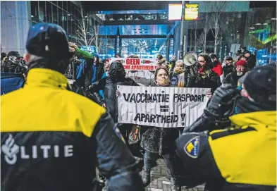  ?? AFP ?? "Pase de vacunación, igual al apartheid", dice la pancarta en una protesta en Holanda