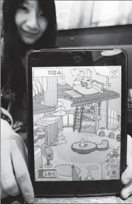  ?? KYODO NEWS VIA GETTY IMAGES ?? A gaming enthusiast displays a scene from Tabikaeru, or Travel Frog, on a tablet.