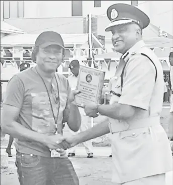  ?? ?? Michael Jordan receives from Commission­er of Police (ag) Seelall Persaud an award for Assisting the Police to solve a Cold Case in 2016.