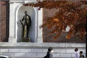  ??  ?? Pedestrian­s pass a statue of Alexander Hamilton at the City Museum of New York