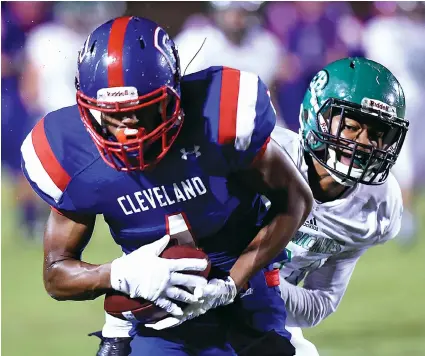  ?? STAFF PHOTO BY ROBIN RUDD ?? Cleveland’s Syler Davis pulls in a reception ahead of East Hamilton’s Samuel Blakemore during Friday night’s game at Cleveland. Davis scored on the play, and the Blue Raiders won 34-6.