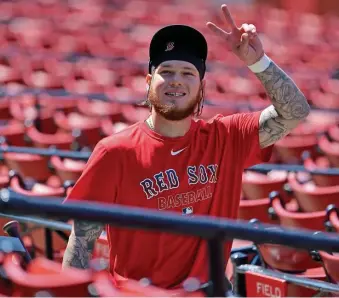  ?? STUART CAHILL / HERALD STAFF ?? LIKING HIS NEW HOME: Right fielder Alex Verdugo flashes a peace sign at photograph­ers as he walks to practice Saturday.