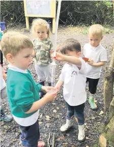  ??  ?? Well earned rest Nursery kids stop for refreshmen­ts during their fun nature trail