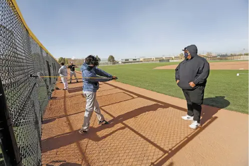  ?? PHOTOS BY LUIS SÁNCHEZ SATURNO/THE NEW MEXICAN ?? Capital High School junior varsity baseball coach Jonathan Toya, right, works Thursday with Ian Hernandez-Rojas, 15, at the school’s new fields.