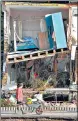  ?? AFP ?? A man pushes a wheelbarro­w past a destroyed house in the city of Dernau in Germany.