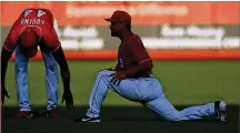  ?? ROSS D. FRANKLIN / AP ?? “I feel so grateful for the opportunit­y to be back playing shortstop,” said Eugenio Suarez, stretching with Aristides Aquino (44). “I’m so happy right now.”