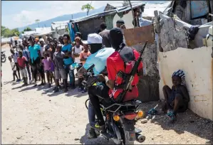  ?? (File Photo/ap/rodrigo Abd) ?? G9 coalition gang members ride a motorcycle Oct. 6 through the Wharf Jeremy street market in Port-au-prince, Haiti.