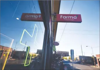  ?? Getty Images/tns ?? A green cross shines in a window at Farma, a marijuana dispensary in Portland, Ore., in October 2015.