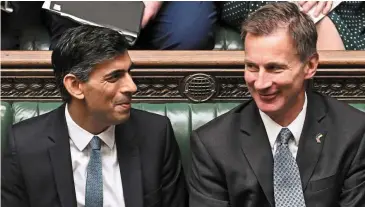  ?? — AFP ?? Reaching a consensus: Sunak (left) and Hunt in the House of Commons. Both argue that there is no alternativ­e to their fiscal tightening given the urgent need to tame inflation.