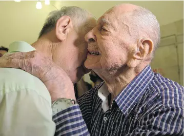  ?? SEBASTIAN SCHEINER / THE ASSOCIATED PRESS ?? Israeli Holocaust survivor Eliahu Pietruszka, right, embraces Alexandre Pietruszka as they meet for the first time in Kfar Saba, Israel. Pietruszka, who fled Poland at the beginning of the Second World War and thought his entire family had perished,...