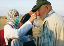  ?? ASSOCIATED PRESS PHOTOS BY ADEL HANA ?? Palestinia­n paramedic Asmaa Qudih sprays a homemade antitear gas liquid on a man near the fence of the Gaza Strip border with Israel, during a protest last month. Treating the wounded has become a dangerous mission for Gaza’s emergency workers.
