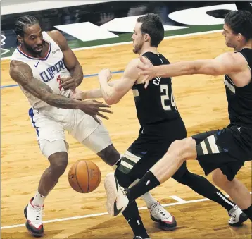  ?? MORRY GASH — THE ASSOCIATED PRESS ?? The Milwaukee Bucks’ Brook Lopez kicks a ball thrown by the Clippers’ Kawhi Leonard during the first half.