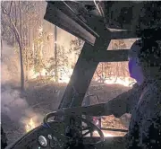  ?? REUTERS ?? A firefighte­r sits in a fire engine as he watches a bushfire in New South Wales.