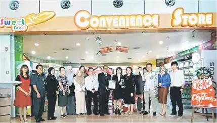  ??  ?? Mohd Nadzim (front, sixth right) presents the award to Lim, witnessed by Sik Choo (front, fourth right) and others during the celebratio­n at KIA.