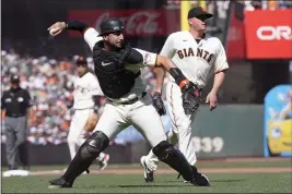  ?? JEFF CHIU — THE ASSOCIATED PRESS ?? San Francisco Giants catcher Joey Bart, left, throws out the Miami Marlins’ Jacob Stallings at first base during the seventh inning Saturday in San Francisco. Also pictured is Giants pitcher Jake McGee.