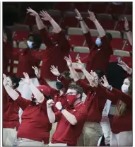  ?? (NWA Democrat-Gazette/Charlie Kaijo) ?? Members of the Hogwild Band raise their arms while calling the Hogs during the second half of Arkansas’ game against Georgia on Jan. 9 at Walton Arena in Fayettevil­le. Despite being unable to play their instrument­s because of coronaviru­s protocols, the band has made its presence known in other ways.