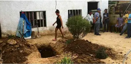  ??  ?? Venezuelan­os em Maracaibo cavam buraco no quintal de casa para enterrar familiar