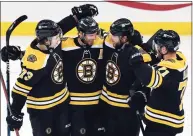  ?? Michael Dwyer / Associated Press ?? The Bruins’ Craig Smith (12) celebrates his hat trick with teammates Charlie McAvoy (73), David Krejci (46) and Taylor Hall (71) against the Sabres on Saturday.