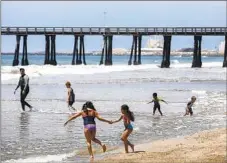  ?? Mel Melcon Los Angeles Times ?? BEACHGOERS play on the sand in Port Hueneme. A ballot initiative, if approved, would rename Port Hueneme as Hueneme Beach.