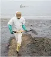  ?? Photo / AP ?? A worker cleans Conchitas Beach contaminat­ed by an oil spill, in Ancon, Peru.