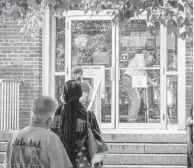  ?? JERRY JACKSON/BALTIMORE SUN ?? Dundalk residents wait outside the post office Friday as they try to pick up delayed mail. U.S. Rep. C.A. Dutch Ruppersber­ger and state Del. Ric Metzgar visited Monday.