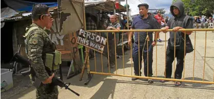  ?? —RICHEL V. UMEL ?? DANGER ZONE Soldiers prevent hundreds of protesters from crossing a bridge to Bangolo District in Marawi City on Tuesday, claiming there were still unexploded bombs in the area. The marchers commemorat­ed the first anniversar­y of the city’s liberation from the terrorists.