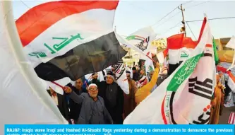  ??  ?? NAJAF: Iraqis wave Iraqi and Hashed Al-Shaabi flags yesterday during a demonstrat­ion to denounce the previous night’s attacks by US planes on several bases. — AFP