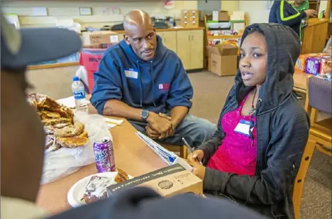 ?? Andrew Rush/Post-Gazette ?? Eldridge Kimbrough, a Pittsburgh police Zone 2 officer, left, talks with student Natalie Hollinger, 17, of the Hill District, on Friday during a youth engagement session at the Student Achievemen­t Center in Homewood.